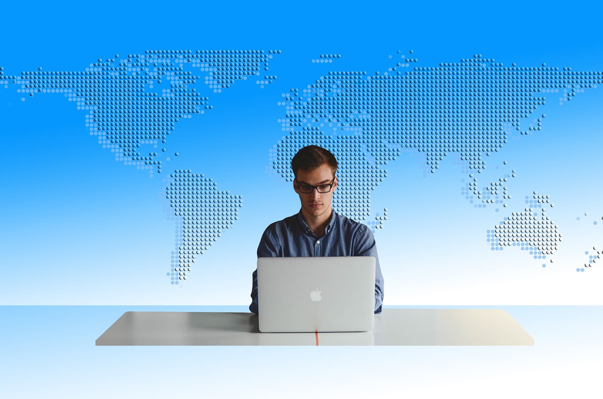 homem sentado em seu computador com os países em volta dele