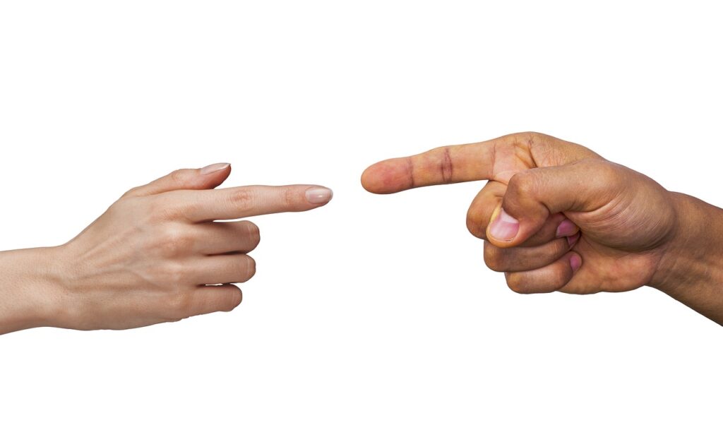 Imagem representando a conexão entre duas mãos, simbolizando união e conexão humana. A mão à esquerda é feminina e a mão à direita é masculina, ambas se tocando.